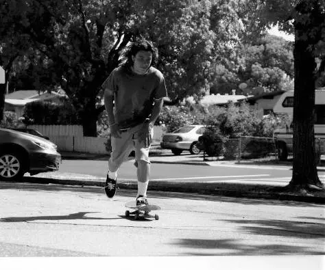 A young man riding a skateboard down the street.